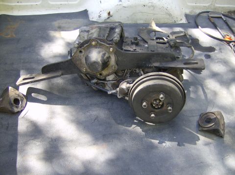 1986 Ford Bronco - Transfer case assembly with brake drum and mounting brackets, likely from a 4x4 vehicle.