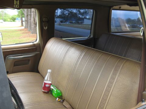 1995 Ford C-350 (Centurion Conversions) - Interior view of a vehicle's bench seat with drinks on it.