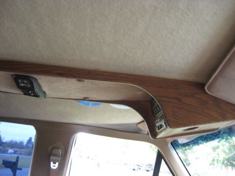 1995 Ford C-350 (Centurion Conversions) - Interior view of a vehicle's overhead console with wood trim and integrated controls.