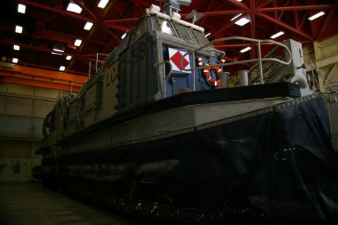 1986 Ford Bronco - A hovercraft, identified by the markings LCAC-59, is parked indoors within a large hangar structure.