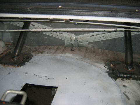 1992 Ford Mustang - A custom roll cage is visible inside the rear of a vehicle, with metal bars welded to the floor panels.