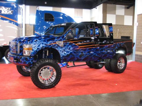 1980 Ford Bronco - This heavily customized pickup truck features a striking blue lightning bolt paint job and is displayed indoors.