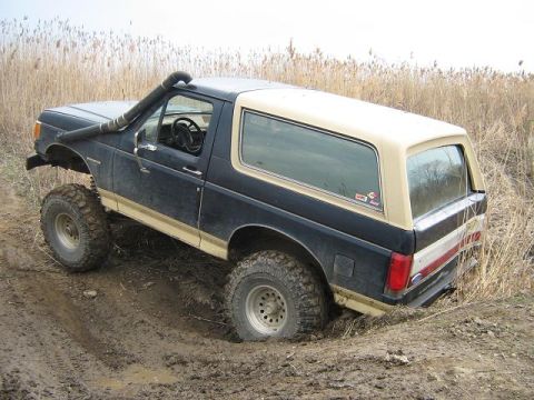 1990 Ford Bronco - This lifted Ford Bronco is navigating a muddy trail with a snorkel installed.