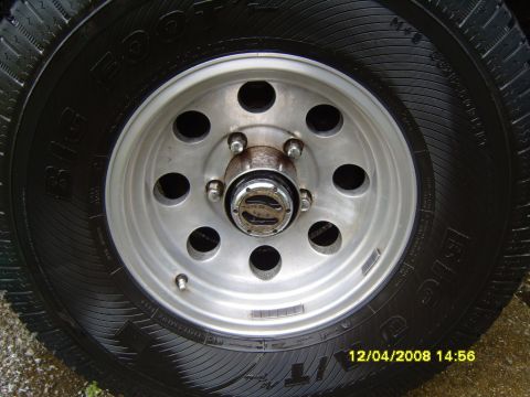 1989 Ford Bronco - A close-up view of a vehicle's wheel and tire, a chrome hubcap and visible tire tread details.