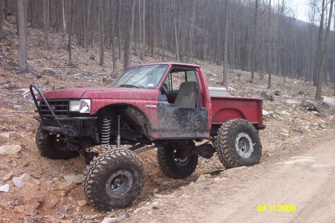 1992 Ford Bronco - This heavily modified 1987 Ford F-150 pickup truck is shown off-road with its doors removed.