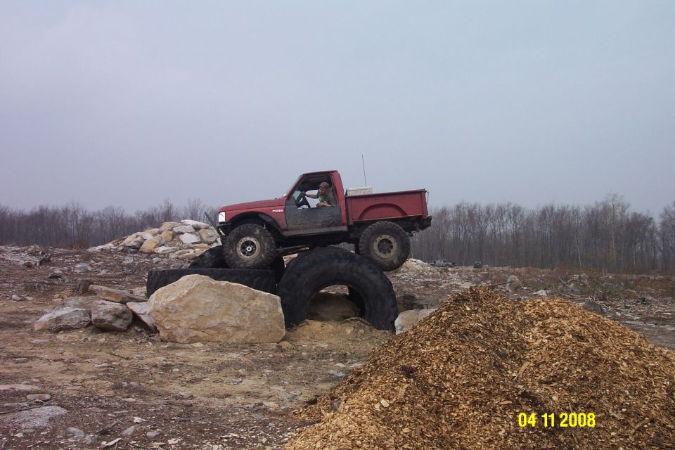 Red pickup truck with large tires on an obstacle course