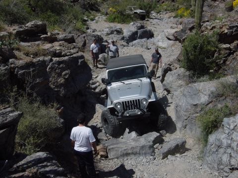2004 Jeep Wrangler - A 2004 Jeep Wrangler tackles a challenging rocky trail, with another vehicle in the background.