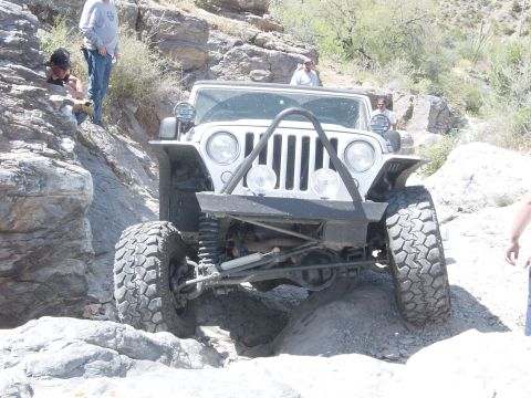 2004 Jeep Wrangler - A white 2004 Jeep Wrangler navigates a challenging rocky terrain during an off-road excursion.
