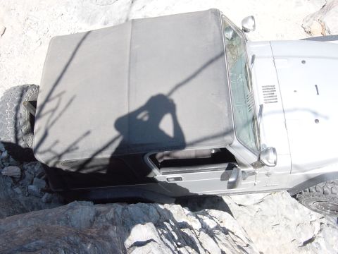 2004 Jeep Wrangler - A silver 2004 Jeep Wrangler navigates a rocky trail, its soft top visible.