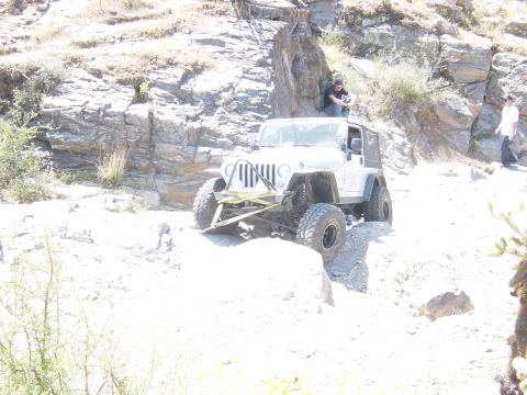 2004 Jeep Wrangler - A white 2004 Jeep Wrangler navigates a challenging rocky terrain during an off-road excursion.