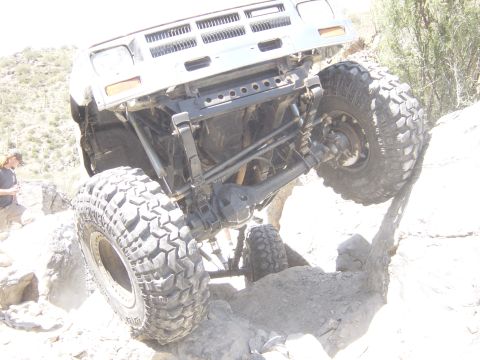 2004 Jeep Wrangler - Vehicle navigating a rocky trail, showing its suspension and large off-road tires.