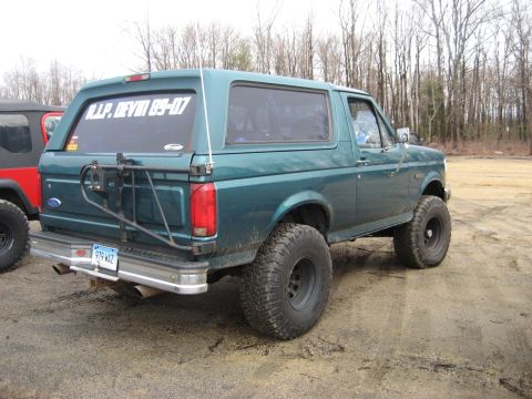 1991 Ford Bronco - 1991 Ford Bronco parked outdoors with a spare tire carrier and a sticker on the rear window.
