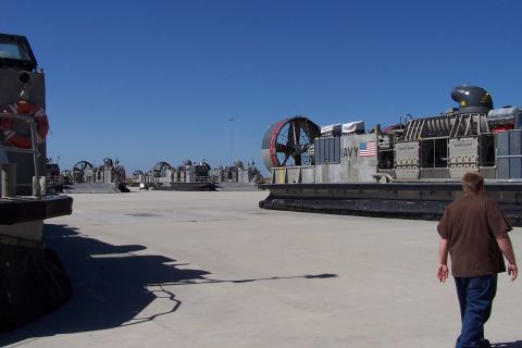 1990 Ford Bronco - US Navy hovercrafts are lined up on a sunny day. One vehicle has 'NAVY' and an American flag visible.