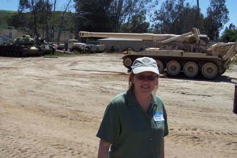 1990 Ford Bronco - A woman poses for a photo in front of several military vehicles, including a tank and a large artillery piece.