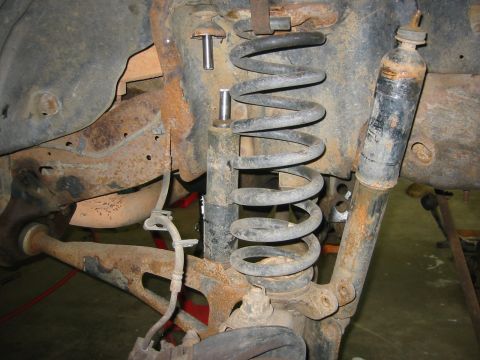 1995 Ford Bronco - Close-up of vehicle's front suspension system, a coil spring and shock absorber.