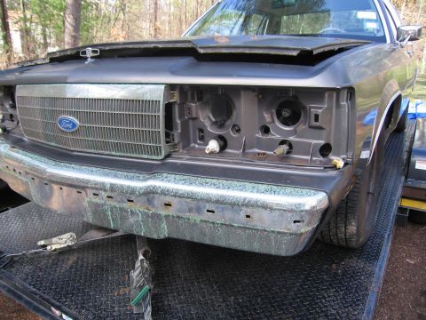 1991 Ford LTD Crown Victoria - The front end of a 1991 Ford Crown Victoria is shown with the hood up and the grille and headlight assemblies missing.