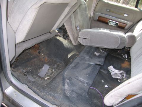 1991 Ford LTD Crown Victoria - The interior of the car shows significant wear and tear on the seats and floor mats.