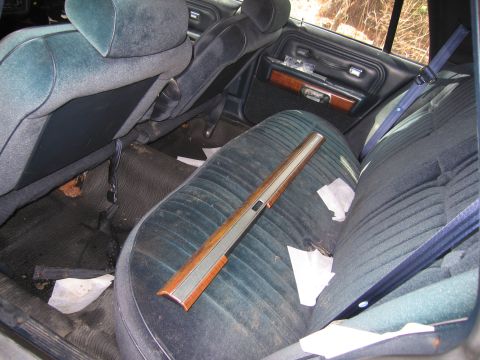 1991 Ford LTD Crown Victoria - The interior of a 1991 Ford Crown Victoria LTD shows blue velour seats and wood trim on the door panel.