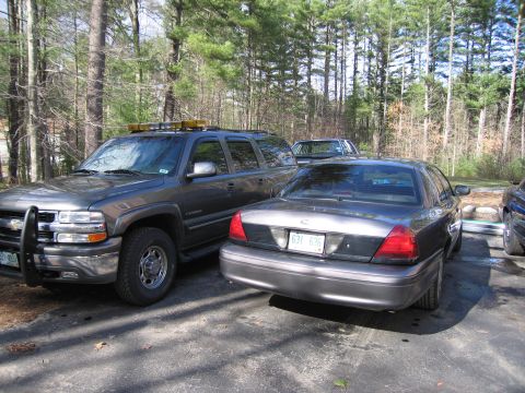 1991 Ford LTD Crown Victoria - A dark gray Ford Crown Victoria is parked in a driveway next to a large SUV.