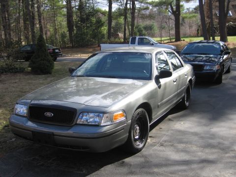 1991 Ford LTD Crown Victoria - A gray sedan, possibly a Ford Crown Victoria, is parked in a driveway with other vehicles visible.