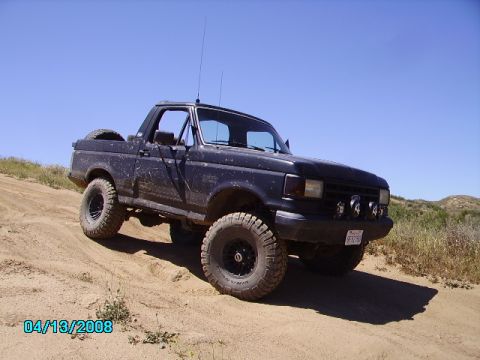 1990 Ford Bronco - 1990 Ford Bronco off-road with aftermarket wheels and lights.