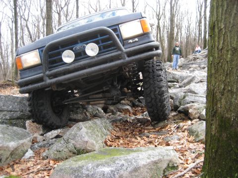 1991 Ford Bronco - This 1991 Ford Bronco tackles a challenging off-road course, demonstrating its capabilities on rough terrain.