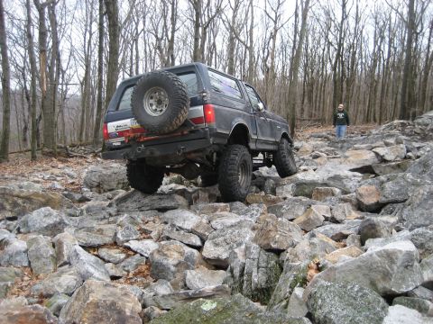 1991 Ford Bronco - Ford Bronco tackles a challenging rocky terrain, demonstrating its off-road capabilities.