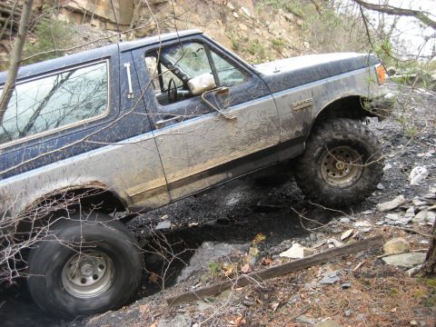 1991 Ford Bronco - This 1991 Ford Bronco navigates a challenging off-road course, its two-tone paint covered in mud.