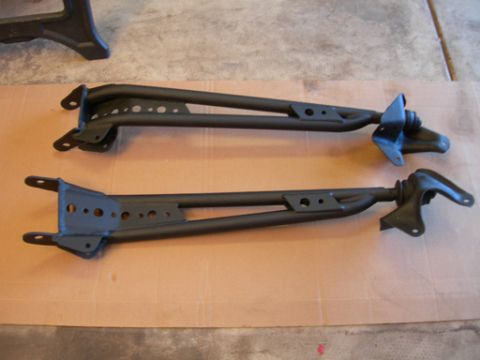 1985 Ford Bronco - Two black suspension control arms are shown, likely for a vehicle restoration or upgrade project.
