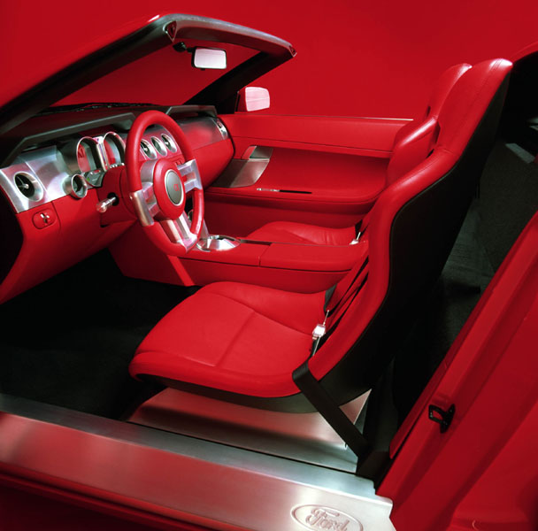 Red leather car interior with aluminum dash and steering wheel, Ford sill badge