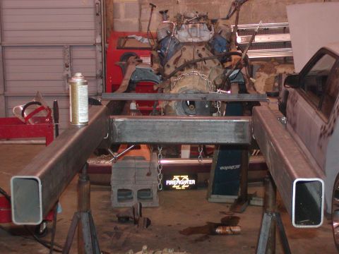1991 Ford Bronco - Engine and frame parts are visible in a workshop setting with tools and equipment around.