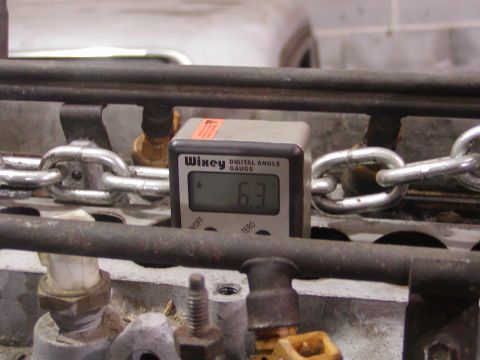 1991 Ford Bronco - A digital angle gauge is used to measure an angle on engine parts, with chains visible in the background.