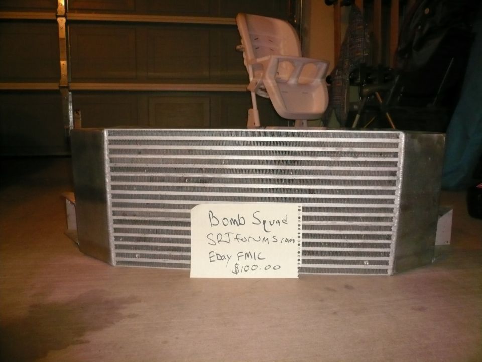 Aluminum intercooler with a sign that reads "Bomb Squad SRTforums.com Ebay FMIC $100.00"