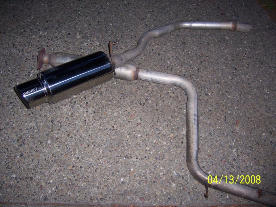Aftermarket exhaust muffler and pipe assembly on concrete