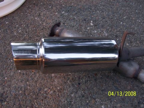1994 Ford Probe - A shiny aftermarket exhaust muffler with the brand name 'megan' visible on the tip.
