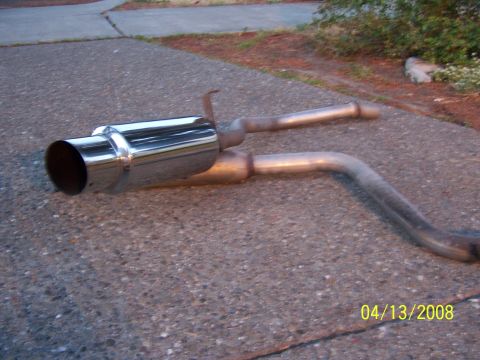 1994 Ford Probe - An exhaust system with a shiny chrome tip rests on a concrete surface.