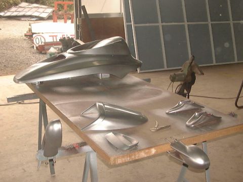 1994 Ford Bronco - Various car body parts are laid out on a workbench, possibly for repair or customization.