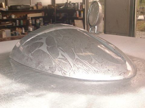1994 Ford Bronco - Custom fender with an etched pattern and a side mirror attached, likely in a workshop setting.