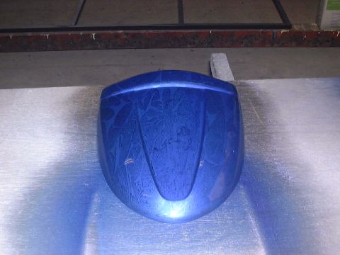 1994 Ford Bronco - A blue painted car part with a decorative pattern is shown on a flat surface.
