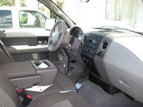 2006 Ford F-150 - The interior of a 2006 Ford F-150 pickup truck is visible, with a second vehicle seen through the side window.