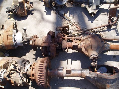 1978 Ford Bronco - A collection of assorted vehicle axles and transfer cases are shown, some with visible brake components and drum brakes.