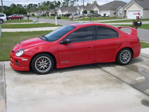 1997 Ford Probe - A red Dodge Neon SRT-4 is shown from a 3/4 front angle on a paved driveway.