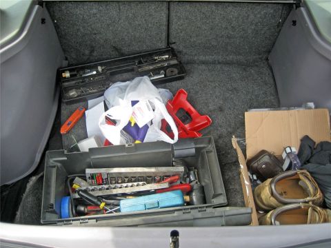 1993 Ford Probe - The trunk of a vehicle is filled with tools, including a large toolbox, a smaller case of sockets, and jack stands, along with other miscel…