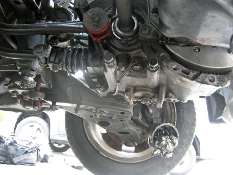 1993 Ford Probe - The underside of a car reveals a damaged CV joint, with another vehicle in the background.
