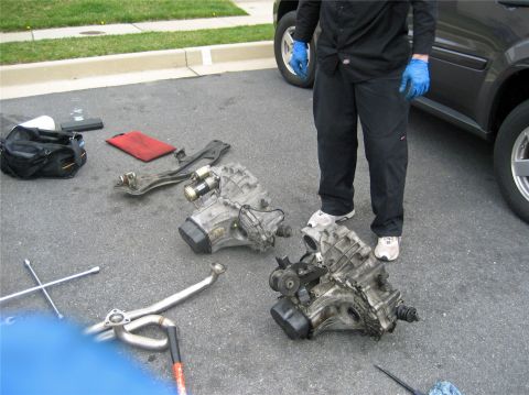 1993 Ford Probe - Car transmissions and tools are laid out on the ground, with a person standing nearby.
