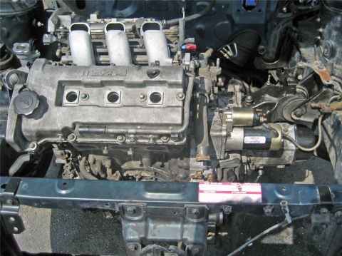 1993 Ford Probe - Engine bay detail showing a Mazda engine and starter motor assembly.