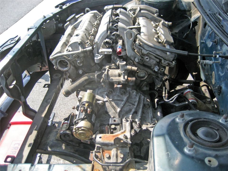 Engine and transmission removed from a car, showing the engine bay