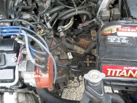 1993 Ford Probe - The engine bay shows a complex arrangement of hoses, wires, and engine components, including a prominent battery.