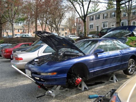 1993 Ford Probe - This blue 1993 Ford Probe is up on jack stands with its hood and trunk open, undergoing maintenance.