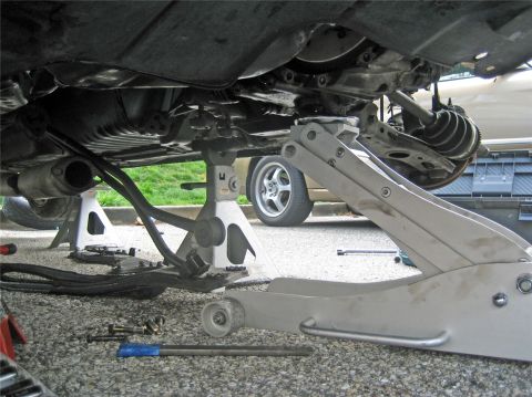 1993 Ford Probe - The underbody of a 1993 Ford Probe GT is shown, lifted on jack stands for maintenance, with suspension and exhaust components visible.
